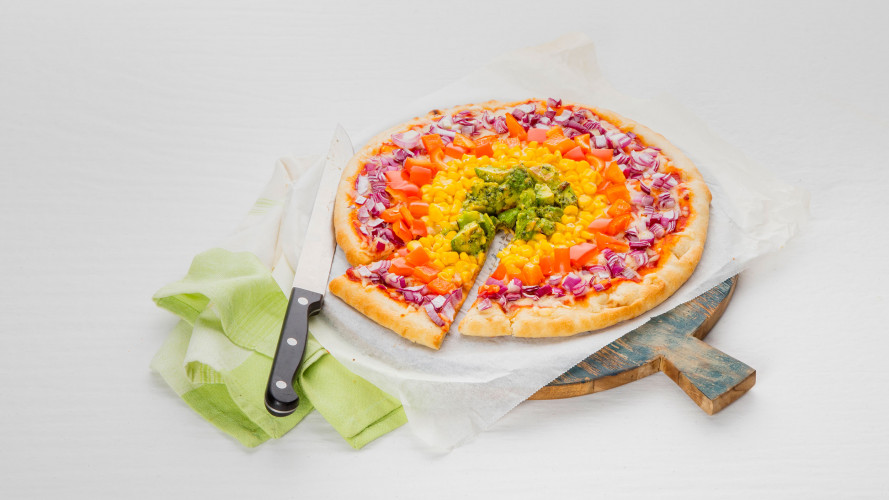 Pizza met regenboog van groenten